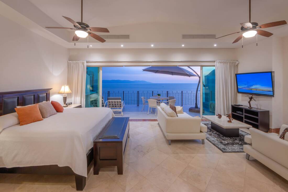 Primary suite with seating area and terrace at dusk
